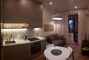 阿拉木图Cozy Urban Retreat的厨房以及带桌子和沙发的客厅。