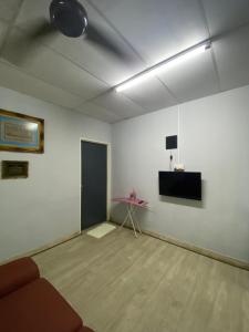 关丹ADEELA HOMESTAY @ BANDAR KUANTAN的一间配有沙发的房间和墙上的电视