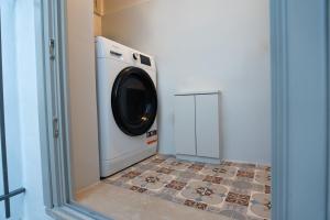 雅典Villa Hermes in Anafiotika Athens !的洗衣房配有洗衣机,铺有瓷砖地板。