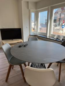 德哈恩De Haan App 1的客厅配有桌椅和电视。