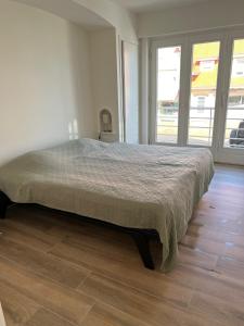 德哈恩De Haan App 1的卧室内的一张大床,铺有木地板