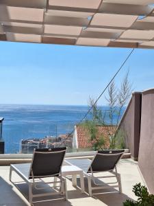 杜布罗夫尼克Luxury Apartment Moobl - Free parking的阳台上配有两把椅子和一张桌子,享有海景
