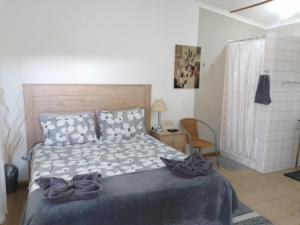 马林塔尔Aub Guesthouse - Mariental的一间卧室配有一张床和一把椅子