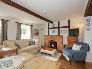 PentneyHorseshoe Cottage的带沙发和壁炉的客厅