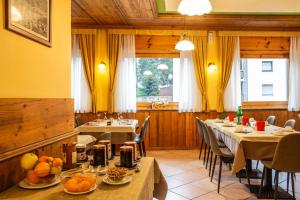 瓦托内切比久酒店的一间餐厅配有桌椅,提供食物
