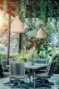 奥拉涅斯塔德RH Boutique Hotel Aruba的种有植物的庭院里的桌椅