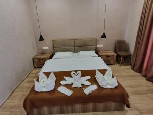 卡兹贝吉Hotel Olympus Kazbegi的一间卧室,床上放着两朵鲜花