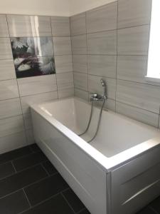 Uršna SelaLepa Dolenjska的浴室内设有带水龙头的白色浴缸