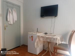 贝洛奥里藏特Aconchego do Lar Centro BH Apto 633 Rua da Bahia 187的客房设有桌子、电视和冰箱。