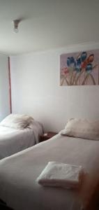 Nueva ImperialEl Rincon de los Poetas的一间卧室设有两张床,墙上挂着一幅画