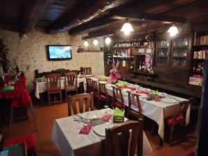BuggianoI Casali del Buontempo的一间带桌椅和电视的用餐室