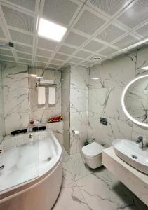 伊斯坦布尔THE PARK HOTEL的带浴缸、卫生间和盥洗盆的浴室