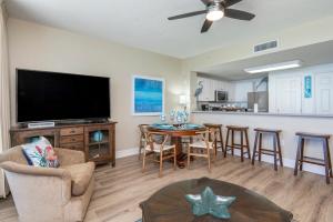 巴拿马城海滩Stunning Ocean & Sunset Views, Direct Beach Access with 2 King Bedrooms at Panama City Beach, Fl的一间带电视和桌子的客厅