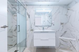 阿玛考德佩拉Vieira Azul的带淋浴和盥洗盆的白色浴室