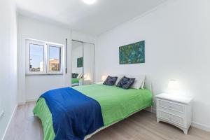 阿玛考德佩拉Vieira Azul的白色的卧室设有绿色的床和窗户
