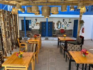 库斯科CASA CRISTOBAL Siete Cuartones CASONA COLONIAL的餐厅设有木桌和椅子以及蓝色的门