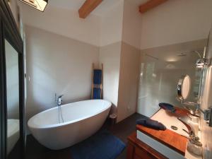 普罗旺斯艾克斯Lou Pantai, Bed and Breakfast, Delux Bedroom的浴室配有大型白色浴缸和水槽