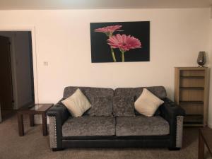 阿伯丁Infiniti properties的客厅的沙发,墙上挂着粉红色的花