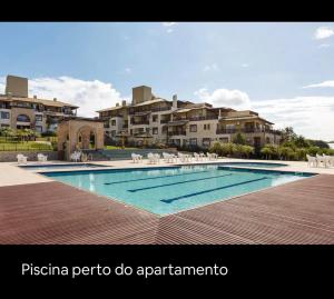 弗洛里亚诺波利斯UNICO Apto atendendo a 8 anos seguidos familias Dentro Resort Costao do Santinho COM RECEPÇÃO PERSONALIZADA COM MIMOS SURPRESA NO SEU CHECKIN xxxxxxxxxxxxxxx NOT ALL INCLUSIVE的部分公寓大楼前的游泳池