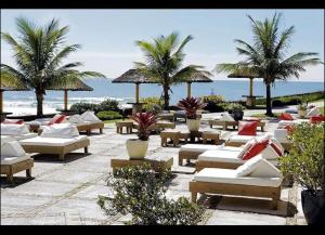 弗洛里亚诺波利斯Apartamento Dentro Resort Costao do Santinho NOT ALL INCLUSIVE的海滩上一排躺椅和棕榈树