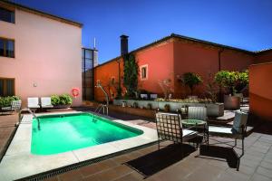 特鲁希略依赞特鲁希略酒店的一座带椅子的庭院内的游泳池以及一座建筑