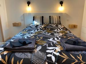 热拉梅Duplex le Corten, Terrasse et jardin的床上配有被子和毛巾