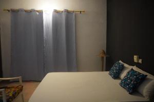 OuidahAu cœur de Ouidah 2的卧室配有白色的床和窗帘