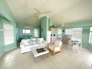 Conch BarDragon Cay Resort Mudjin Harbour的客厅配有沙发和桌子