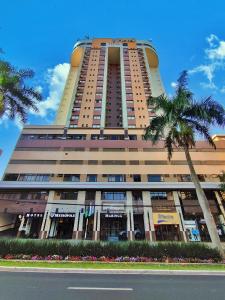 马林加玛琳加梅特罗普尔酒店的一座高大的建筑,前面有一棵棕榈树
