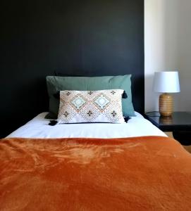 格洛斯特2 Bedroom House in Quiet Area, Close to M5 With Free Parking by Glos Homes Ltd的一张带橙色毯子和枕头的床