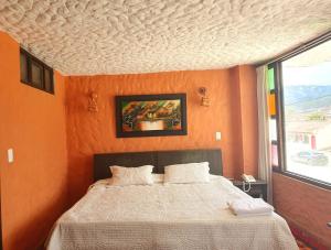 派帕HOTEL COMPOSTELLA的一间卧室配有一张橙色墙壁的床