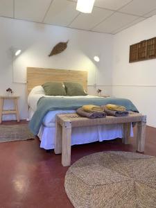 乌玛瓦卡Buena Vista Hostel的一间卧室配有一张床和一张桌子,上面配有毛巾