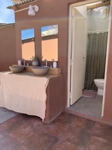 乌玛瓦卡Buena Vista Hostel的一间带两个盥洗盆和卫生间的浴室