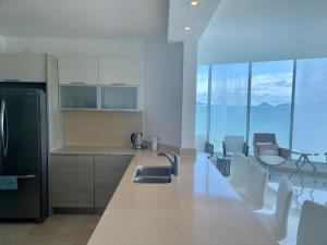 普拉亚伯尼塔村17E Beautiful 2-Bedroom Ocean View Apartment的厨房配有水槽和带椅子的柜台。