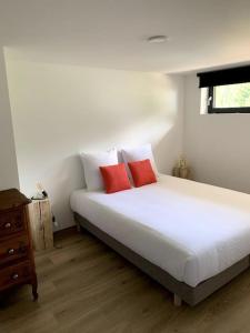 Ban-sur-Meurthe-ClefcyLe Perchoir - Gîte 7 personnes / pleine nature / Altitude : 830 m的卧室配有带红色枕头的白色床