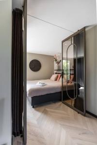 阿尔克马尔The Mini Villa的一间卧室配有一张床和一面大镜子
