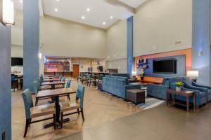 韦科Comfort Suites Waco North - Near University Area的大堂配有沙发、桌子和电视。