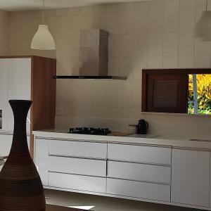 伊塔帕里卡岛维拉克鲁兹Lagoa dourada - Ilha de Itaparica - Salvador da Bahia - Club Med的厨房配有白色橱柜和炉灶烤箱。