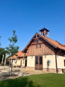 布热茨拉夫Zámeček - Chateau Lány的一座大型木制建筑,顶部设有钟楼