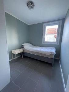 拉尔维克Larvik appartment in the city的一间小卧室,配有床和窗户