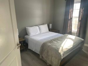 布卢明顿Beautiful 3 BR Townhome - Recently Updated!的一间卧室配有一张带白色床单的床和一扇窗户。