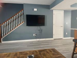 布卢明顿Beautiful 3 BR Townhome - Recently Updated!的客厅设有蓝色墙壁上的平面电视。