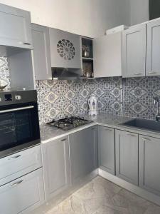 斯法克斯Dar Lella Hasna的厨房配有白色橱柜和炉灶烤箱。
