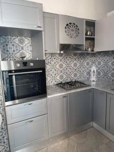 斯法克斯Dar Lella Hasna的厨房配有白色橱柜和炉灶烤箱。