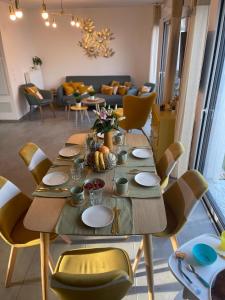 圣纳泽尔Villa des Cerisiers的一间带桌椅和沙发的用餐室
