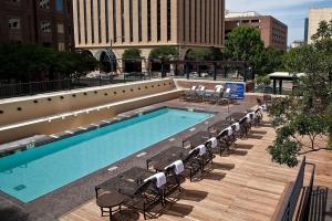 奥斯汀DoubleTree Suites by Hilton Hotel Austin的一座带椅子的大型游泳池和一座建筑