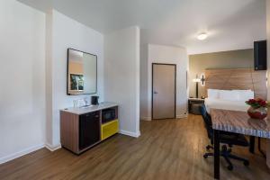 尤巴城尤巴城旅程住宿酒店的配有一张床、一张桌子和一张桌子的酒店客房