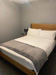 贝尔法斯特Modern Hut in Belfast的卧室配有一张带白色床单和枕头的大床。