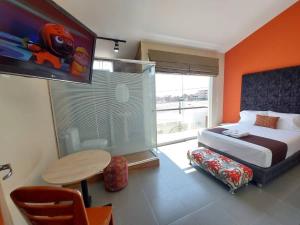 伊洛Apart Hotel Atenea的一间卧室配有一张床、一张桌子和一台电视。