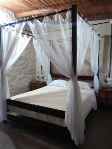 La CarolinaPosada Casablanca的卧室配有带白色窗帘的天蓬床